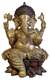 Escultura de Ganesha em bronze, com detalhes intricados e adornos, sentado sobre uma flor de lótus.