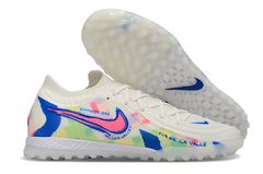 Chuteira Society Nike Phantom GX II Elite TF em cores brancas com detalhes coloridos e logo azul.