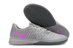 Chuteira futsal Nike Lunar Gato II IC na cor cinza com detalhes em roxo.