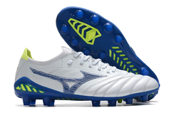 Chuteira Mizuno MORELIA NEO III β Made In Japan FG na cor branca com detalhes em azul e verde, ideal para campo.