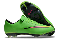 Chuteira de futebol Nike Mercurial Vapor X FG na cor verde com detalhes em rosa e sola transparente.