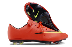 Chuteira campo Nike Mercurial Vapor X FG na cor laranja, com detalhes em preto e amarelo, exibindo a sola e o design aerodinâmico.