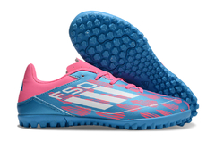 Chuteira Society Adidas F50 Club nas cores azul e rosa, com solado de borracha para melhor tração em campos sintéticos.