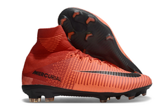 Chuteira campo Nike Mercurial Superfly 5 na cor laranja, destacando seu design e solado com cravos.