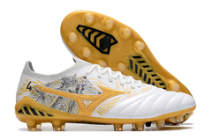 Chuteira Mizuno MORELIA NEO III β Made In Japan FG em branco e dourado, com detalhes de leões na lateral.