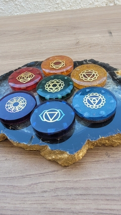 Imagem do Kit de orgonites dos sete chakras com símbolos em metal dourados, pedras e cores correspondentes