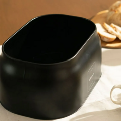 Porta pão sense preto em uma mesa com a tampa aberta