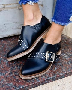 Zapato Negro de cuero con detalle de tira cruzada y herraje de tachas.