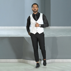 Hombre posando con chaleco jacquard blanco y camisa negra, luciendo elegante y moderno.