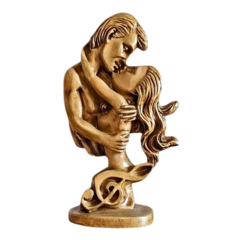 Escultura em gesso de um casal se beijando, representando almas gêmeas, com detalhes em dourado.