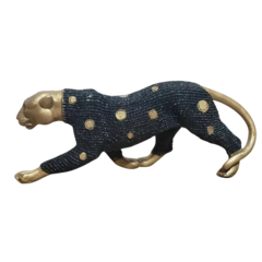 Escultura de uma pantera caçadora preta com detalhes em dourado, posicionada em uma pose de caça.