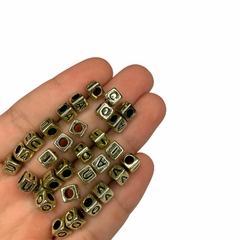 Miçanga - Dado metalizado dourado com vogais pretas - 6mm (25 gramas)