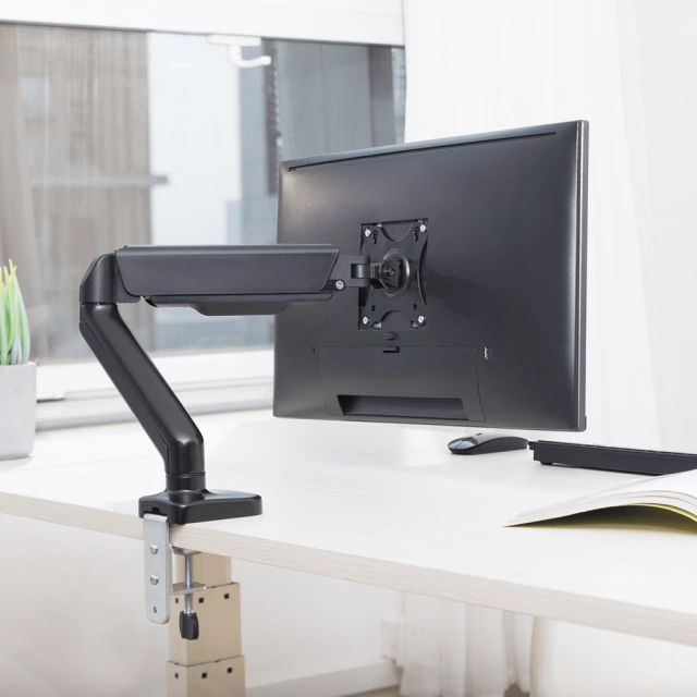 foto do suporte de monitor slikdesk, cor preta, com um monitor preto sob uma besa branca
