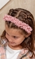 Nena con Vincha Eider rosa, de textura acanalada con moño y puntilla