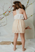 Nena con la blusa Hibisco off white, con puntilla en el delantero, combinado con la falda Petunia beige
