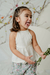 Nena con remera Azucena off white, escote halter de algodón con recorte de tul en pechera combinado con el short Abelia fondo verde