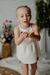 Nena con remera Lirio off white, de micropanal con puntilla en el escote, con el short Abelia, fondo lila