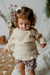 Beba con sweater Peonia beige y shorts Abelia fondo lila 