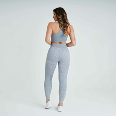 Modelo usando calça legging feminina cinza mescla da Marcio May Sports, vista traseira