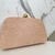 Bolsa clutch arredondada rose com detalhes dourados na internet
