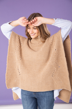 Poncho en lana tejida con detalle de cuello polera. Abierto a los costados. En color tostado.