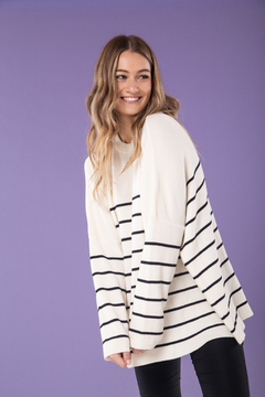 Sweater en hilo de lana viscosa con cuello a la base y detalles en rayas. En color blanco combinado con negro.