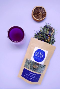 chá violeta servido em xícara de vidro e pacote de chá azul de clitoria, capim cidreira e laranja.