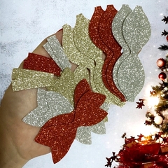 Conjunto de recortes em lonita com glitter nas cores vermelho, dourado e prateado, formando laços e tiras, ideal para decoração de Natal.