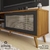 Rack Para Sala com espaço para TV de Até 60'' com Pés Retrô e Porta de Correr em Tela de PVC estilo Palha - NT 1175 na internet